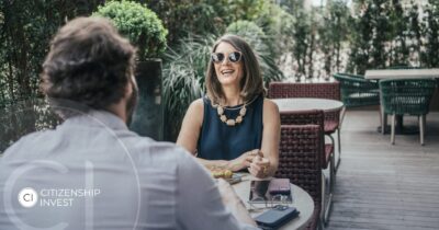 Latin American woman enjoying lunch outdoors, representing investors seeking residency by investment